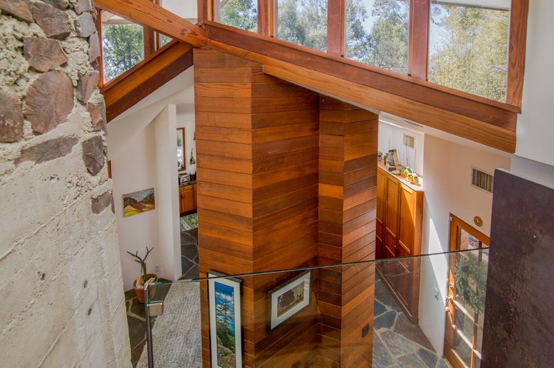 Overhead view of a column of redwood beams under clerestory windows. 